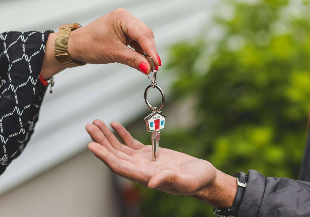one hand giving another a key
